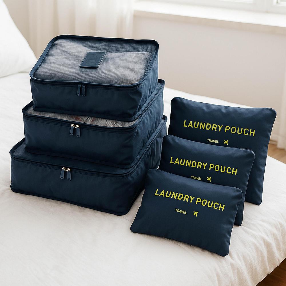 Set of navy packing cubes on a bed