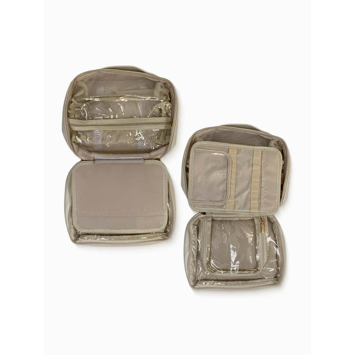 Set of beige travel organizers with clear compartments on a white background