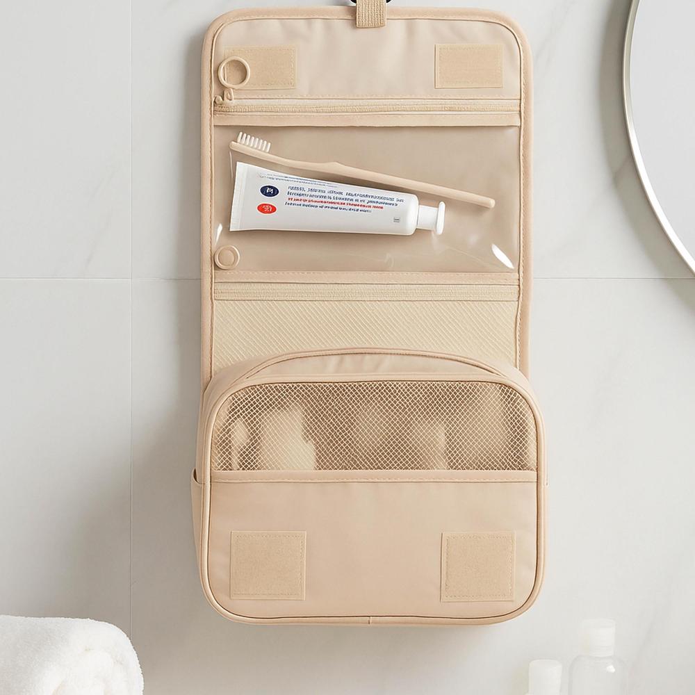 Beige travel toiletry bag with mesh pocket on a white surface