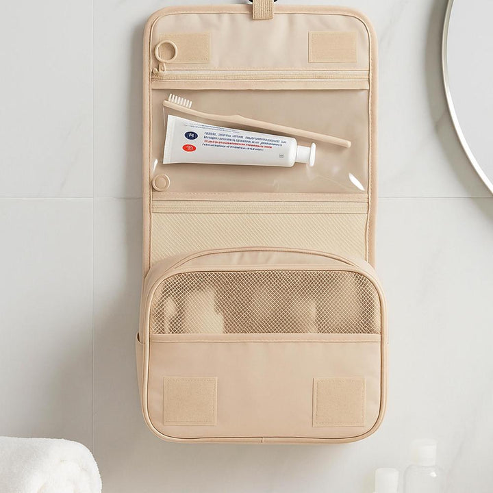 Beige travel toiletry bag with mesh pocket on a white surface